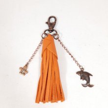 Bijou de sac avec pompon en cuir de vachette coloris orange.