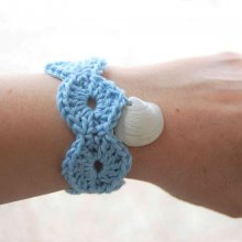 Bracelet adulte crocheté main avec un fil coton bleu clair, un bouton rond 2 trous et un véritable coquillage ramassé sur la plage percé naturellement