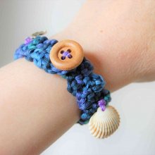 Bracelet adulte crocheté main avec un fil coton bleu vert violet, un bouton rond 4 trous en bois, trois breloques ancre, voilier, cœur métal avec inscription made with love et véritable coquillage