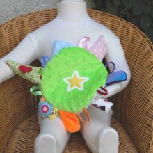 Doudou bébé rond comme la terre avec des rubans et des pièces de tissus autour