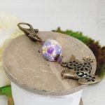 porte clé pedentif colombe de la paix couleur bronze et perle fleuri jaune et violet