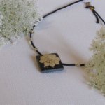 Pendentif Ras du Cou pour Femme en Ardoise avec une Fleur Ecrue monté sur un cordon de Silicone Noir, Création Unique