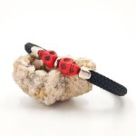 Bracelet double tête de mort en pierres rouges sur grosse corde noire