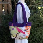 Grand sac en toile, aux couleurs vives et velours uni violet avec perles en bois et bouton fleur