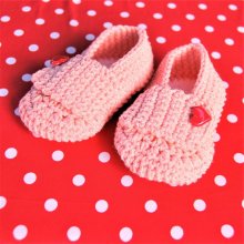 Paire de chaussons roses poupée crochetées main avec un bouton en forme de coeur rouge sur la languette 