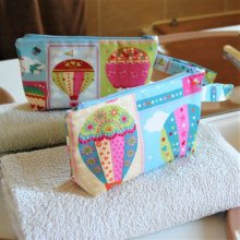 Trousse de toilette en coton turquoise rose motif montgolfières et intérieur beige, zip bleu ciel
