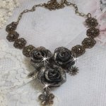 Collier Steampunk Queen crée avec des roses en porcelaine noire et marron, des cabochons en cristal et des accessoires de couleur Bronze