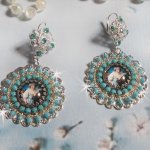 BO Moment de Détente avec des cabochons d’une femme posant son bras sur un drap ou un fauteuil. S’ajoute des cristaux : cabochons et chaîne strass, chaîne perlée Turquoise, estampes et dormeuses