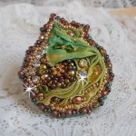 Bague Lune Vénitienne brodée avec un ruban de soie Orange, Vert et Jaune, cristaux : toupies, perles rondes nacrées et chatons. S’ajoute des facettes et rocailles en Verre sur une bague filigranée 