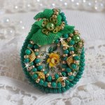 Bague Belle Emeraude brodée avec un cabochon ovale en céramique représentant une rose Jaune sur fond Blanc, un tissu léger de couleur Vert, des perles rondes nacrées et des rocailles Dorées