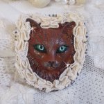 Masque Chat Rocky aux Yeux Verts tout en Fimo brodé avec un dentelle beige très fine, des perles rondes nacrées en Cristal de Swarovski, de la peinture et des rocailles