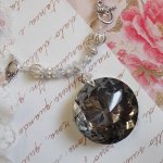 Collier pendentif Coco brodé avec des cristaux de Swarovski et un médaillon cristal fumé