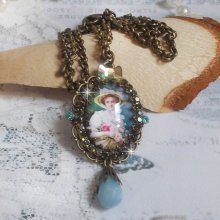 Pendentif Douce Dame créé avec un cabochon représentant une femme au chapeau blanc orné de cristaux, des accessoires de couleur Bronze et un jade teinté bleu 