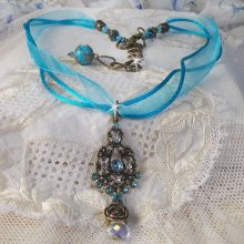 Collier pendentif Lady in Blue monté avec des cristaux de Swarovski, des intercalaires fleurs, des coupelles feuillage et des rubans