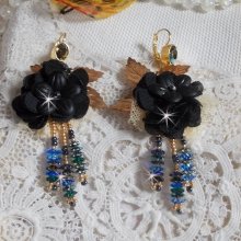 BO Attrape Rêves Noires et Dorées avec fleurs Lucites Noires sur une dentelle Beige et une estampe. Les pendants sont des fleurs en cristal avec des rocailles. Montées avec des dormeuses en Laiton