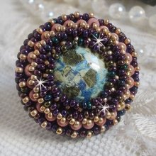 Bague Bonjour Paris cabochon marbré bleu/vert/écru ornée de rocailles Miyuki dont la couleur dominante est le Violet. Montés sur bague dorée en laiton et sur une feutrine Bleu néon. Un look city !